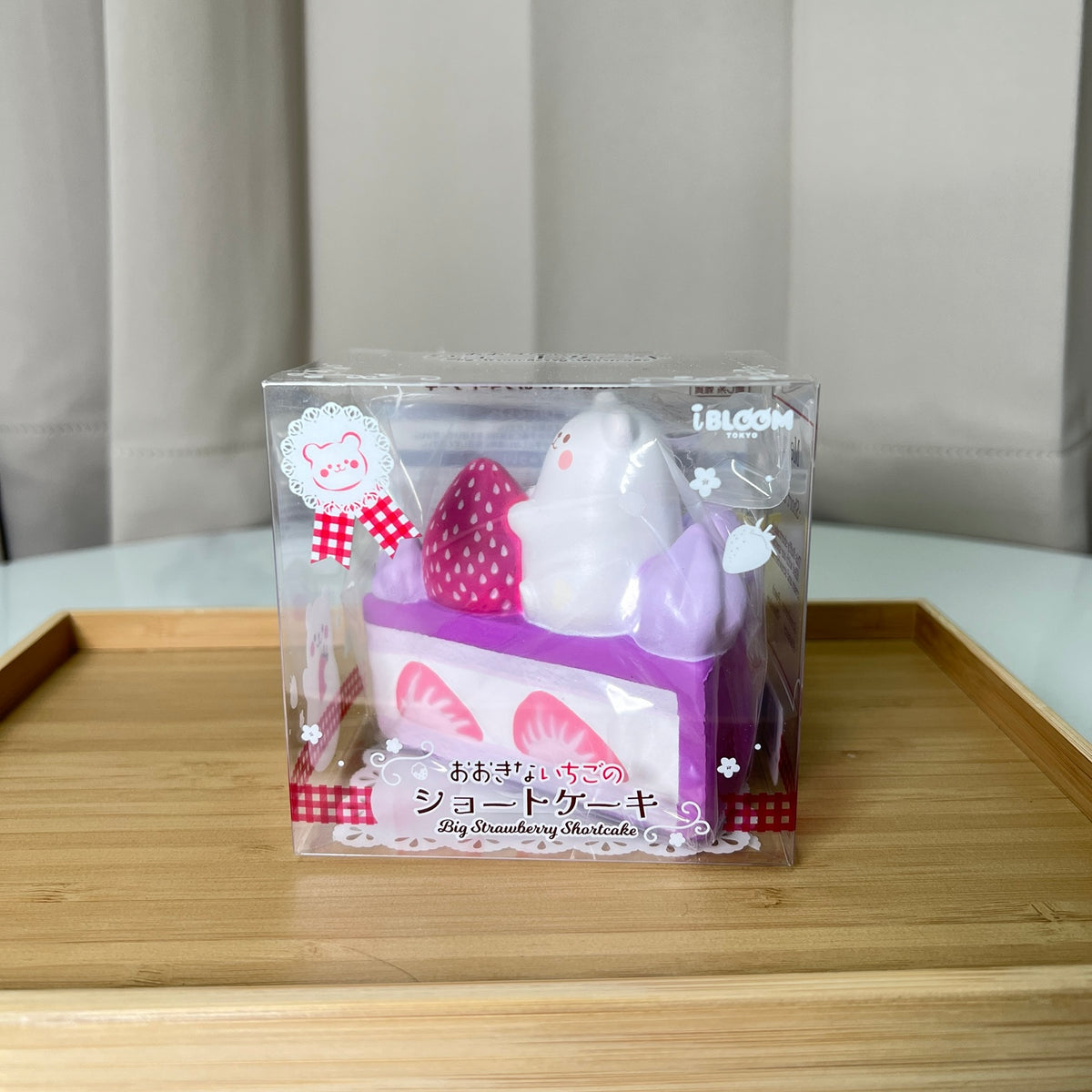 iBLOOM Big Strawberry Shortcake Blueberry Cake squishy front view in clear box, featuring Marmo bear, purple frosting and strawberry