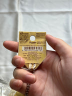 Back of original Sanrio Pompompurin squishy hang tag showing barcode 4901610564813 and aged paper creases